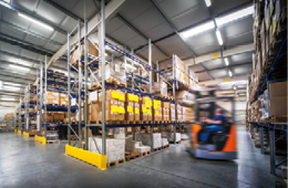 warehouse interior wit blurred forklift and worker in logistic center