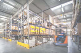 warehouse interior wit blurred forklift and worker in logistic center