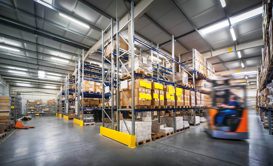 warehouse interior wit blurred forklift and worker in logistic center